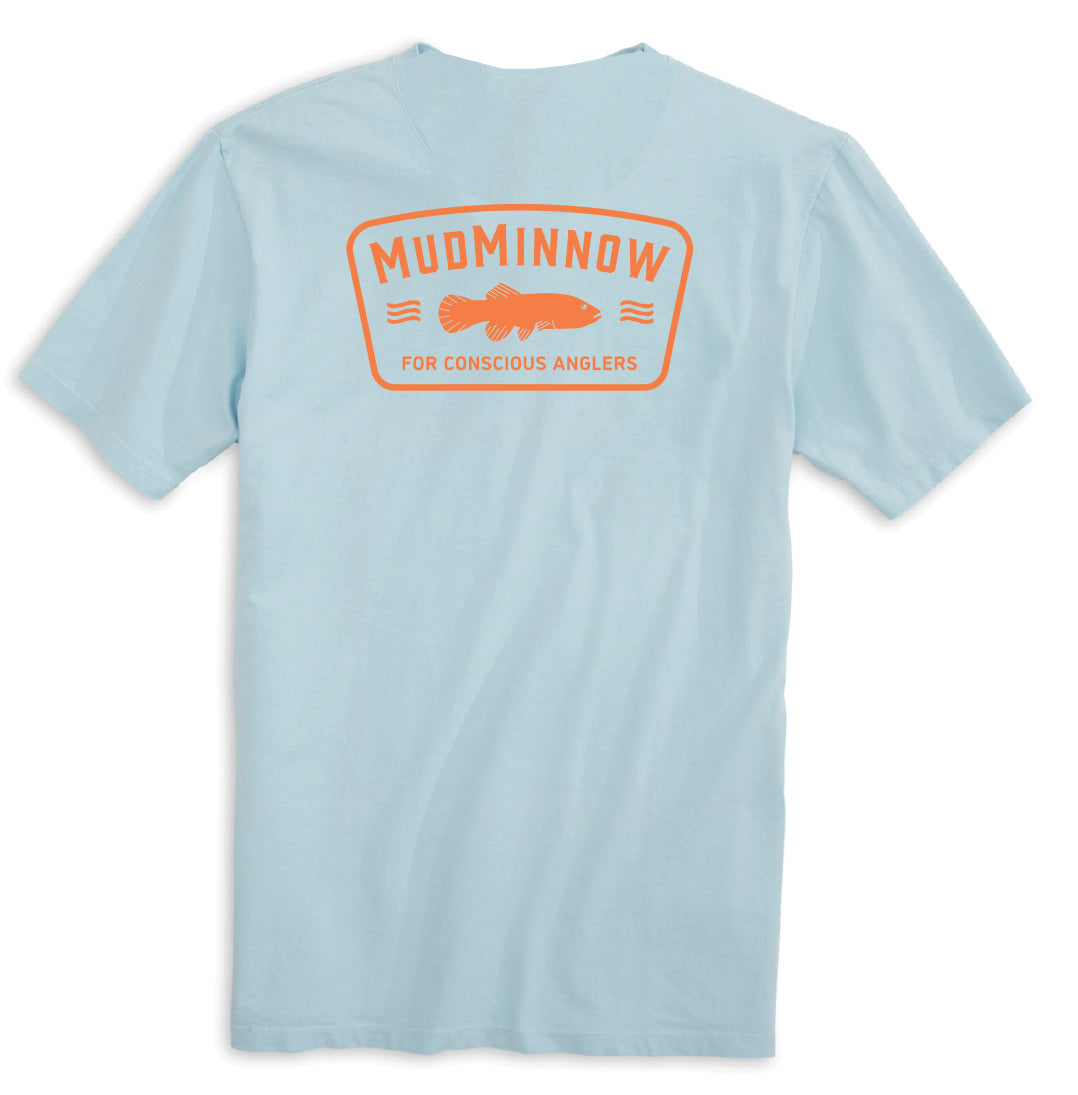 Light blue t-shirt with orange back print reading 'MUDMINNOW FOR CONSCIOUS ANGLERS' above fish graphic